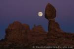 The famous Balanced Rock in Arches National Park is accompanied by the full moon during dusk in the State of Utah, USA.