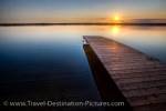 Like a sheet of glass leading on from the end of the wharf, the water of Lake Audy in Riding Mountain National Park reflects the hues in the sky during sunset.